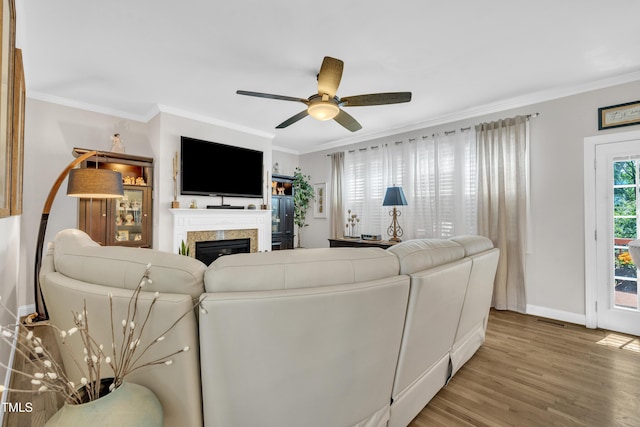 126 Gwendolyn Way, Fuquay Varina, NC 27526 - living room featuring light wood-style flooring, crown molding, ceiling fan, and a glass covered fireplace