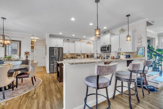 126 Gwendolyn Way, Fuquay Varina, NC 27526 - kitchen with appliances with stainless steel finishes, ornamental molding, light wood-style flooring, a peninsula, and backsplash