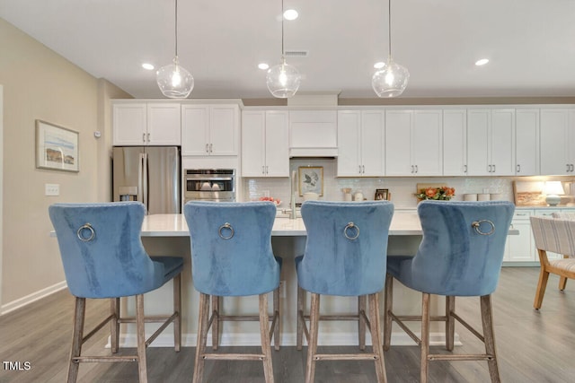 3010 Shady Sage Way Lot 15, Apex, NC 27523 - kitchen featuring stainless steel appliances, backsplash, an island with sink, white cabinetry, and light countertops