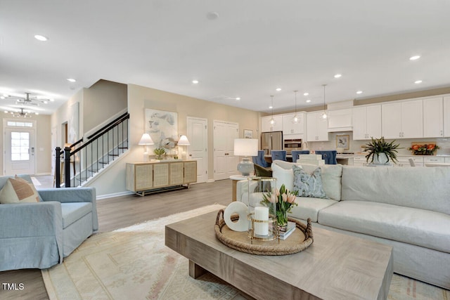 3010 Shady Sage Way Lot 15, Apex, NC 27523 - living area featuring stairs, light wood finished floors, recessed lighting, and a chandelier