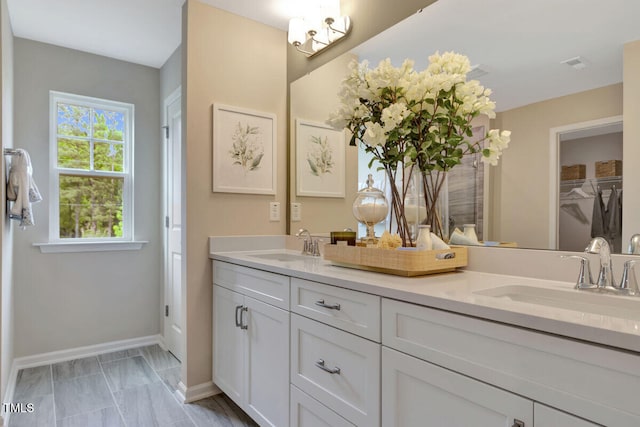 3010 Shady Sage Way Lot 15, Apex, NC 27523 - bathroom featuring double vanity, marble look tiles, and a walk in closet