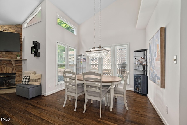 316 Boltstone Ct, Cary, NC 27513 - dining room with dark wood-style flooring, a fireplace, high vaulted ceiling, and a chandelier