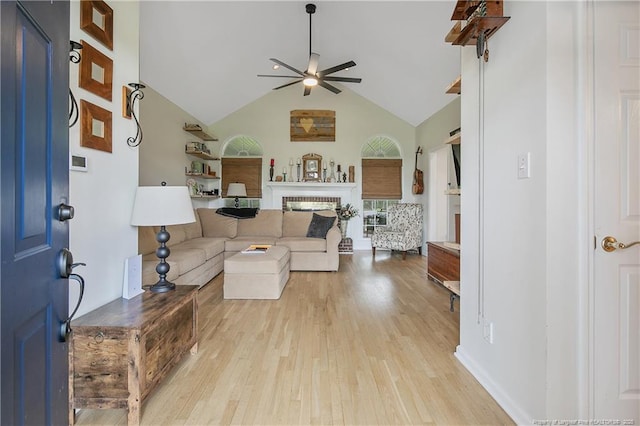 7655 Lucinda Ln, Linden, NC 28356 - living room featuring a ceiling fan, light wood-type flooring, a fireplace, and high vaulted ceiling