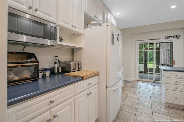 7655 Lucinda Ln, Linden, NC 28356 - kitchen with stainless steel microwave, white cabinets, freestanding refrigerator, dark countertops, and recessed lighting