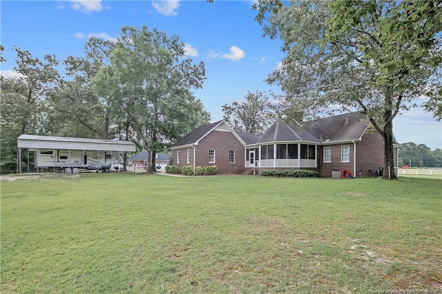 7655 Lucinda Ln, Linden, NC 28356 - rear view of property featuring brick siding, a detached carport, and a sunroom