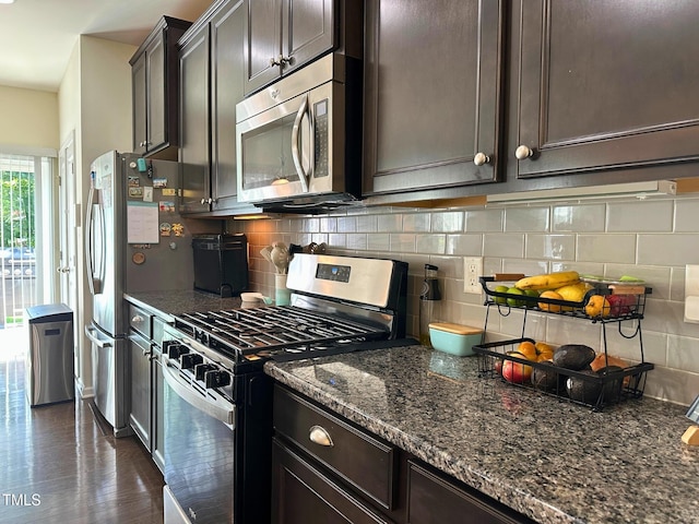 505 Poplar St, Durham, NC 27703 - kitchen featuring stainless steel appliances, dark stone countertops, backsplash, and dark brown cabinetry