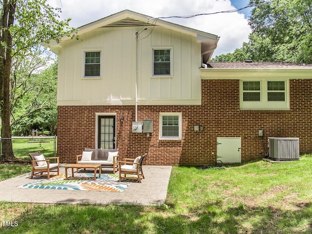 3009 Omah St, Durham, NC 27705 - back of house featuring board and batten siding, an outdoor living space, a patio, and brick siding
