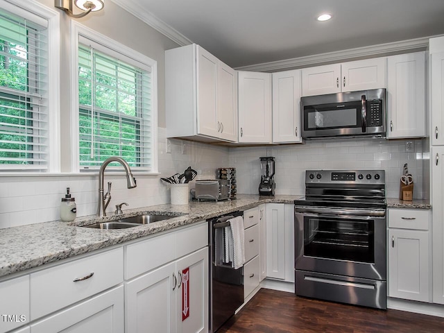 3009 Omah St, Durham, NC 27705 - kitchen with stainless steel appliances, ornamental molding, decorative backsplash, white cabinetry, and dark wood-style floors