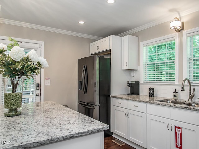 3009 Omah St, Durham, NC 27705 - kitchen featuring stainless steel fridge with ice dispenser, backsplash, white cabinets, ornamental molding, and light stone countertops