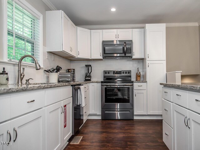3009 Omah St, Durham, NC 27705 - kitchen with stainless steel appliances, backsplash, light stone counters, white cabinets, and ornamental molding