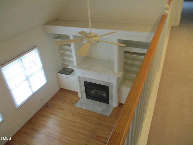 4817 Tupenny Ln, Raleigh, NC 27606 - unfurnished living room featuring ceiling fan, light wood-style flooring, a tiled fireplace, and stairs