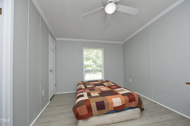 205 N Raleigh Farms Rd, Youngsville, NC 27596 - bedroom with wood finished floors, crown molding, a textured ceiling, a ceiling fan, and a decorative wall