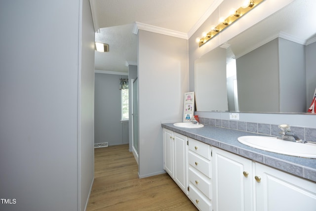 205 N Raleigh Farms Rd, Youngsville, NC 27596 - full bathroom with double vanity, wood finished floors, crown molding, and a textured ceiling