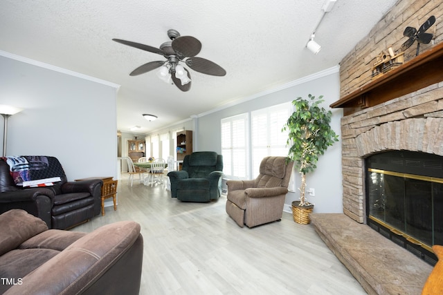 205 N Raleigh Farms Rd, Youngsville, NC 27596 - living room with a textured ceiling, wood finished floors, crown molding, a stone fireplace, and a ceiling fan