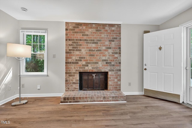 10 Tarawa Ter, Durham, NC 27705 - unfurnished living room with wood finished floors and a brick fireplace