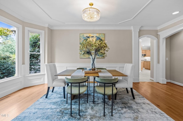 202 Bridewell Ct, Cary, NC 27518 - dining space with wood finished floors, arched walkways, crown molding, a chandelier, and a wainscoted wall