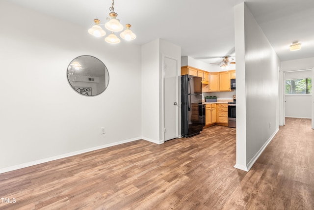 1212 Schaub Dr, Raleigh, NC 27606 - kitchen featuring freestanding refrigerator, light brown cabinetry, stainless steel range with electric cooktop, light countertops, and light wood-style floors