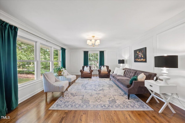 8909 Hunting Trl, Raleigh, NC 27613 - living area with a decorative wall, a chandelier, ornamental molding, and wood finished floors