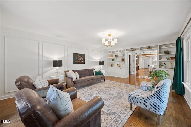 8909 Hunting Trl, Raleigh, NC 27613 - living area with a chandelier, a decorative wall, built in shelves, and wood finished floors