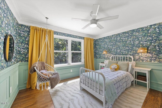 8909 Hunting Trl, Raleigh, NC 27613 - bedroom featuring wallpapered walls, ornamental molding, a wainscoted wall, wood finished floors, and ceiling fan