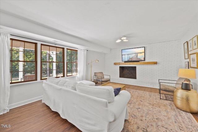8909 Hunting Trl, Raleigh, NC 27613 - living room featuring wood finished floors, a fireplace, and brick wall