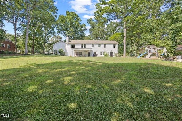 8909 Hunting Trl, Raleigh, NC 27613 - rear view of property featuring a playground, a chimney, and a lawn