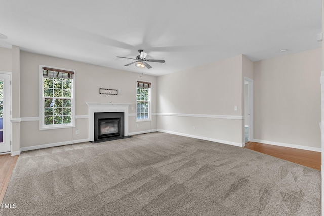 3905 Song Sparrow Dr, Wake Forest, NC 27587 - unfurnished living room featuring a ceiling fan, carpet floors, a fireplace with flush hearth, and wood finished floors