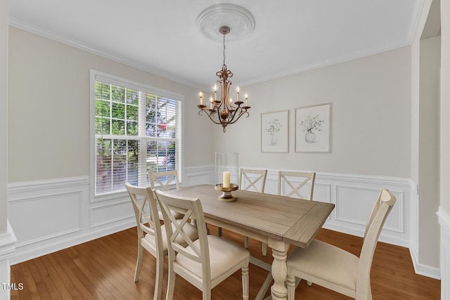 3905 Song Sparrow Dr, Wake Forest, NC 27587 - dining room featuring a chandelier, wood finished floors, wainscoting, ornamental molding, and a decorative wall