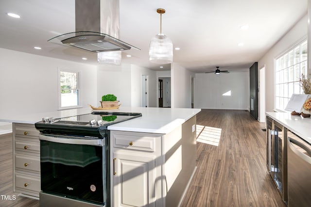 5920 Holly Dr, Raleigh, NC 27616 - kitchen featuring stainless steel appliances, island exhaust hood, light countertops, dark wood finished floors, and recessed lighting