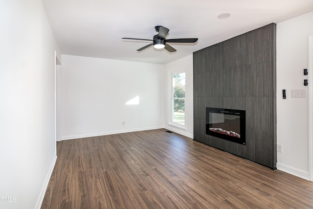 5920 Holly Dr, Raleigh, NC 27616 - unfurnished living room featuring dark wood-type flooring, ceiling fan, and a large fireplace