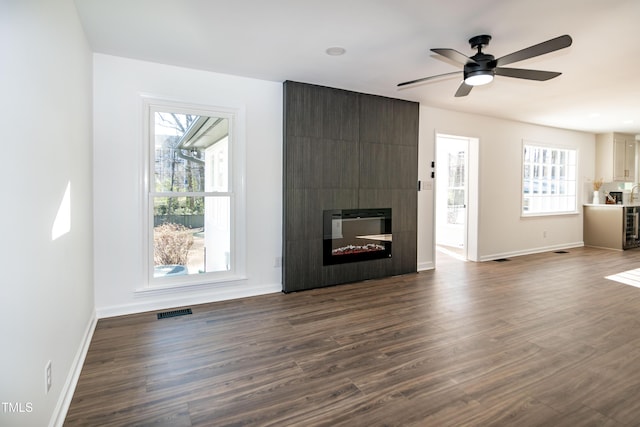 5920 Holly Dr, Raleigh, NC 27616 - unfurnished living room featuring plenty of natural light, dark wood-style floors, and a ceiling fan