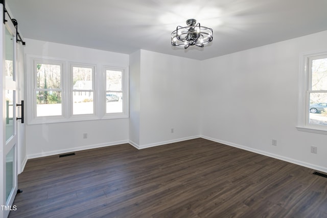 5920 Holly Dr, Raleigh, NC 27616 - unfurnished room with a chandelier, dark wood-style floors, and a barn door