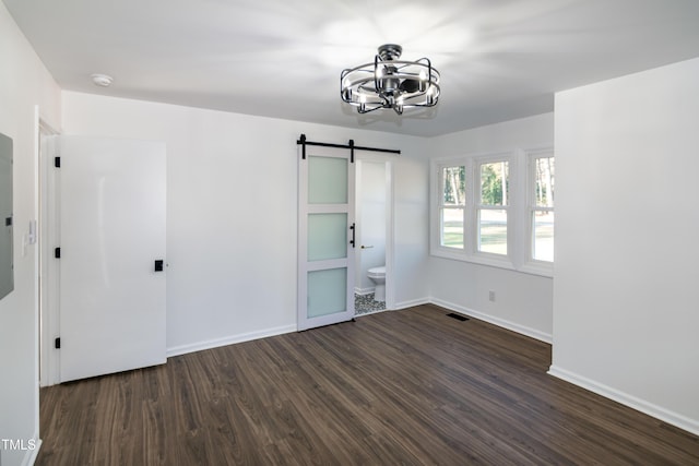 5920 Holly Dr, Raleigh, NC 27616 - spare room with a barn door, dark wood-type flooring, a smoke detector, and a chandelier