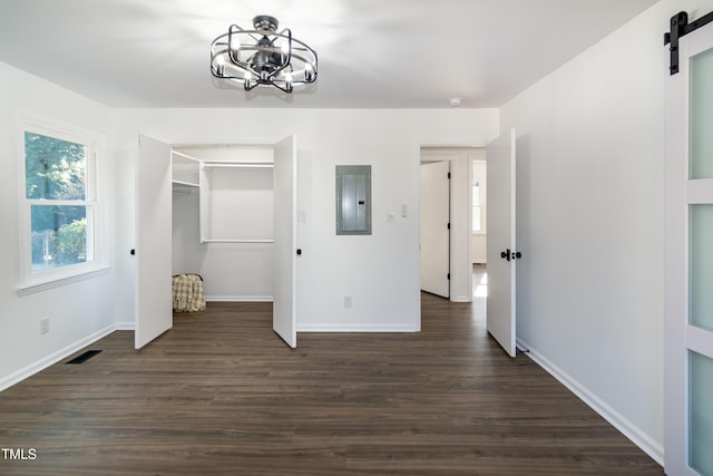 5920 Holly Dr, Raleigh, NC 27616 - unfurnished bedroom featuring a barn door, electric panel, a chandelier, and dark wood-style flooring
