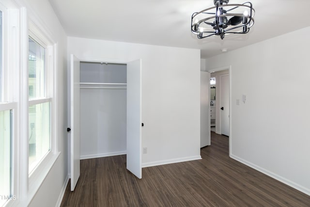 5920 Holly Dr, Raleigh, NC 27616 - unfurnished bedroom with a chandelier, multiple windows, dark wood-style floors, and a closet