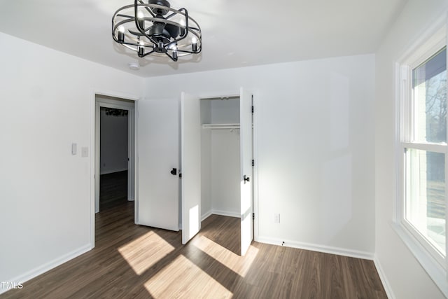 5920 Holly Dr, Raleigh, NC 27616 - unfurnished bedroom featuring a chandelier, wood finished floors, and multiple windows
