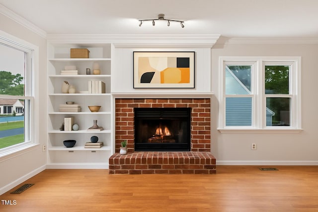 3405 E Jameson Rd, Raleigh, NC 27604 - unfurnished living room with wood finished floors, a brick fireplace, crown molding, and built in features