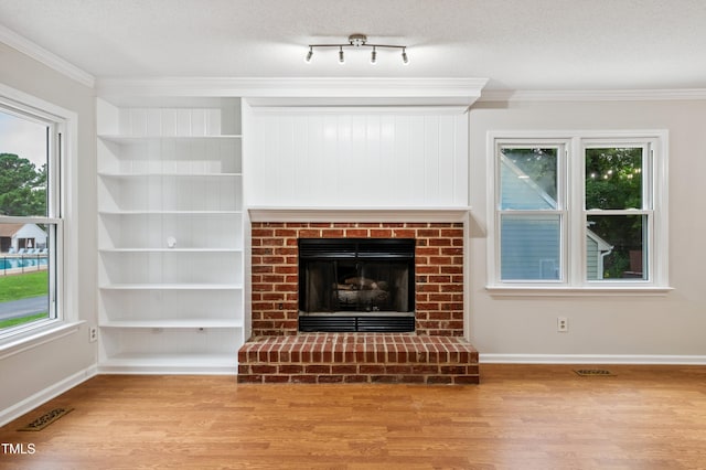 3405 E Jameson Rd, Raleigh, NC 27604 - unfurnished living room with wood finished floors, crown molding, built in shelves, a fireplace, and a textured ceiling