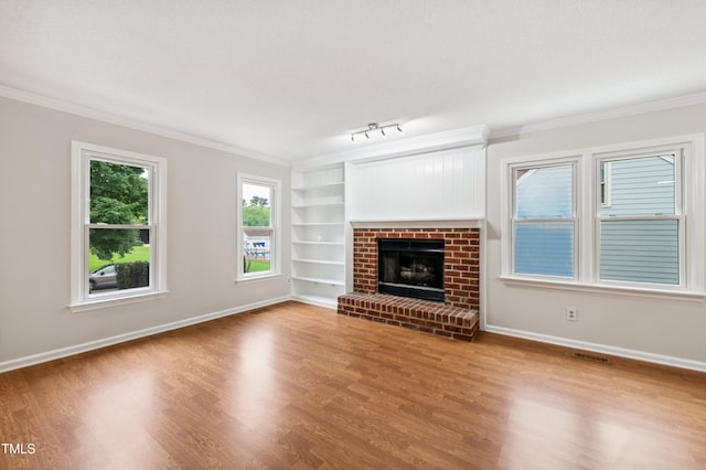 3405 E Jameson Rd, Raleigh, NC 27604 - unfurnished living room featuring built in features, wood finished floors, crown molding, a fireplace, and rail lighting