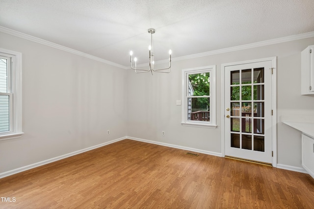 3405 E Jameson Rd, Raleigh, NC 27604 - unfurnished dining area with a chandelier, light wood-style floors, crown molding, and a textured ceiling