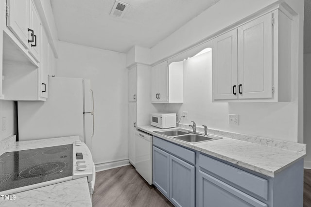 624 Pine Ridge Pl, Raleigh, NC 27609 - kitchen featuring white appliances, dark wood-style floors, light countertops, and white cabinetry