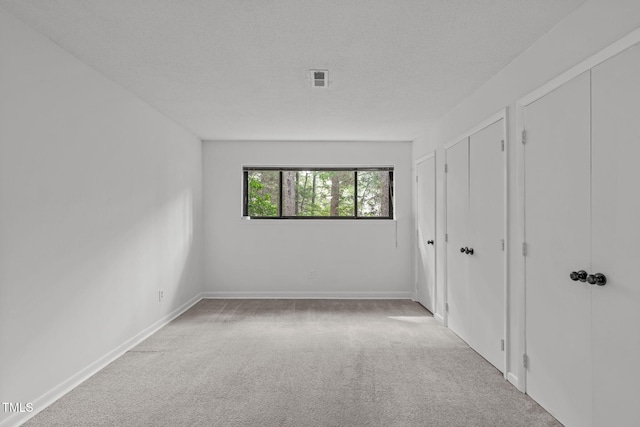 624 Pine Ridge Pl, Raleigh, NC 27609 - unfurnished bedroom with carpet floors, multiple closets, and a textured ceiling