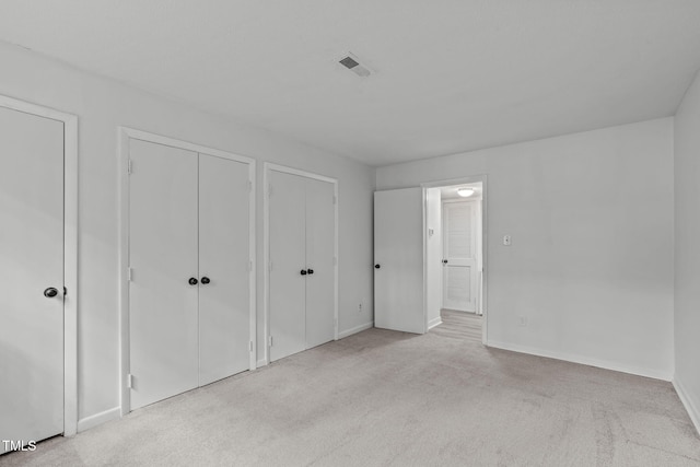 624 Pine Ridge Pl, Raleigh, NC 27609 - unfurnished bedroom featuring two closets and carpet