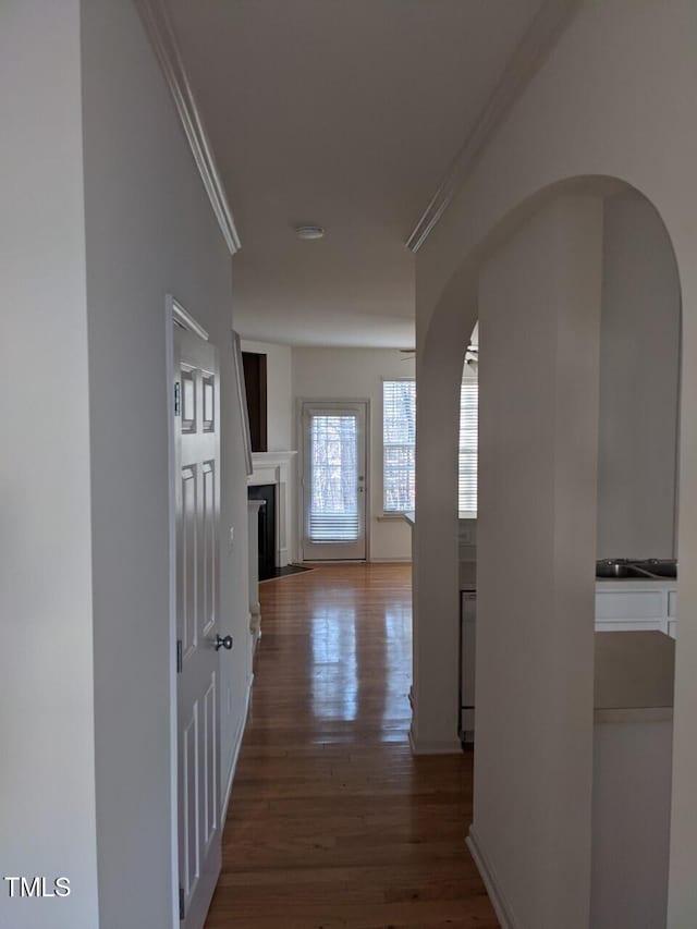 8253 City Loft Ct, Raleigh, NC 27613 - hallway featuring arched walkways, crown molding, and wood finished floors