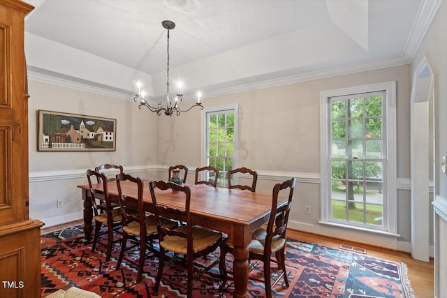12329 Whartons Way, Raleigh, NC 27613 - dining space with a raised ceiling, healthy amount of natural light, a chandelier, wood finished floors, and ornamental molding