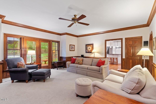 12329 Whartons Way, Raleigh, NC 27613 - living room featuring a wainscoted wall, a ceiling fan, french doors, crown molding, and carpet