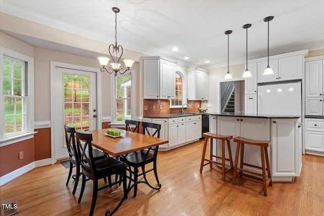 12329 Whartons Way, Raleigh, NC 27613 - dining room featuring ornamental molding, a chandelier, healthy amount of natural light, light wood-style floors, and stairway