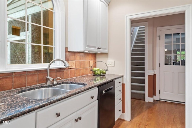 12329 Whartons Way, Raleigh, NC 27613 - kitchen with dishwashing machine, backsplash, dark stone countertops, light wood-type flooring, and white cabinets