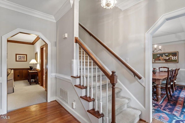 12329 Whartons Way, Raleigh, NC 27613 - staircase featuring a chandelier, crown molding, wood finished floors, and arched walkways