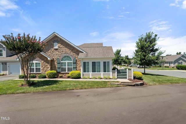 336 Faith Dr, Gibsonville, NC 27249 - traditional-style home featuring stone siding, a front lawn, driveway, and a garage